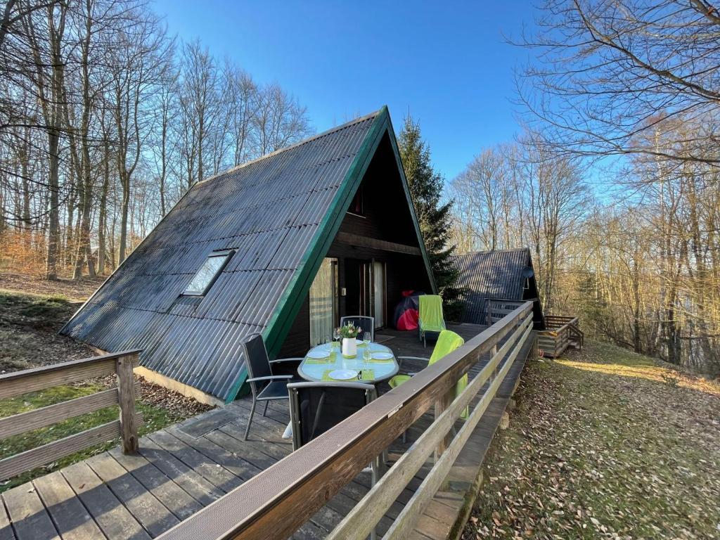 een kleine groene hut met een tafel op een terras bij Chalet Waldglück by Interhome in Bad Arolsen