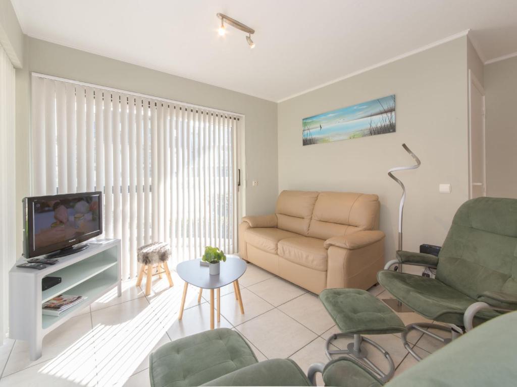 a living room with a couch and a television at Apartment Estepona with parking by Interhome in Mispelburg