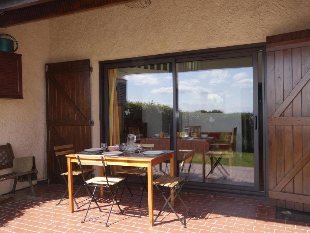 ラ・シオタにあるHoliday Home Les Restanques by Interhomeのパティオ(テーブル、椅子付)、ガラスのスライドドアが備わります。