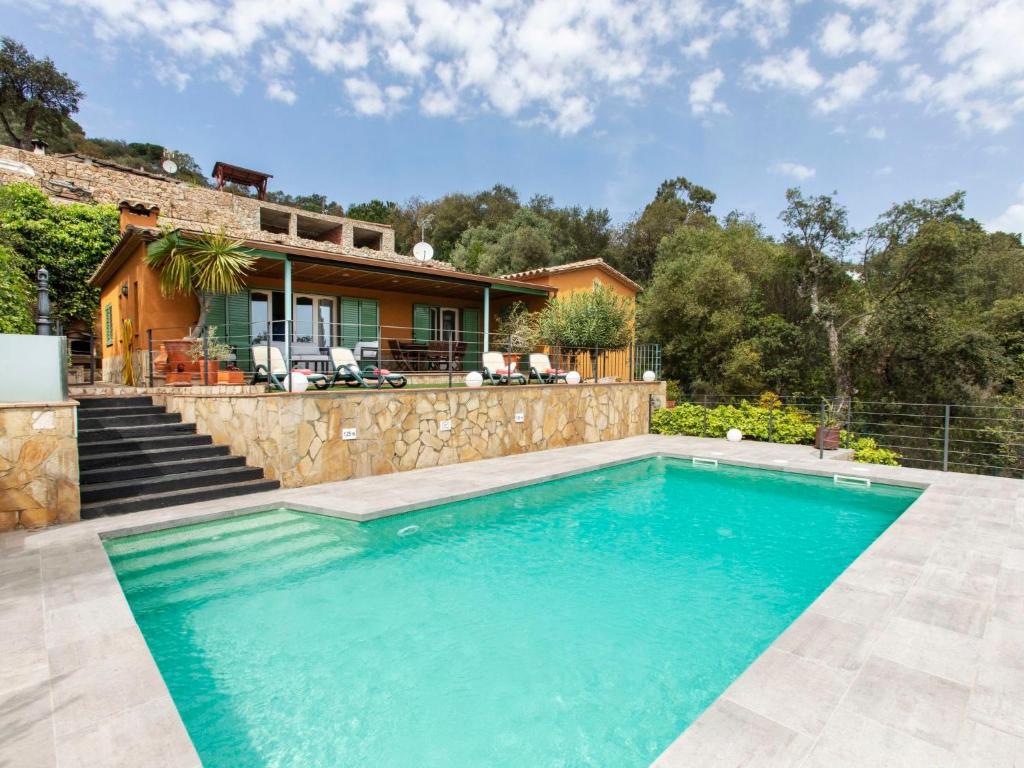 a swimming pool in front of a house at Holiday Home Gloria by Interhome in Calonge