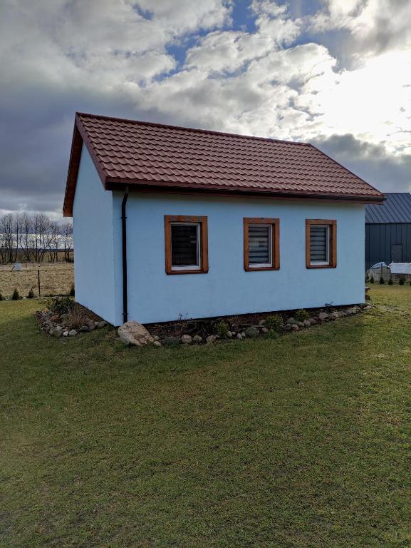 a small white house with a brown roof at Małe Kaszuby in Słajszewo