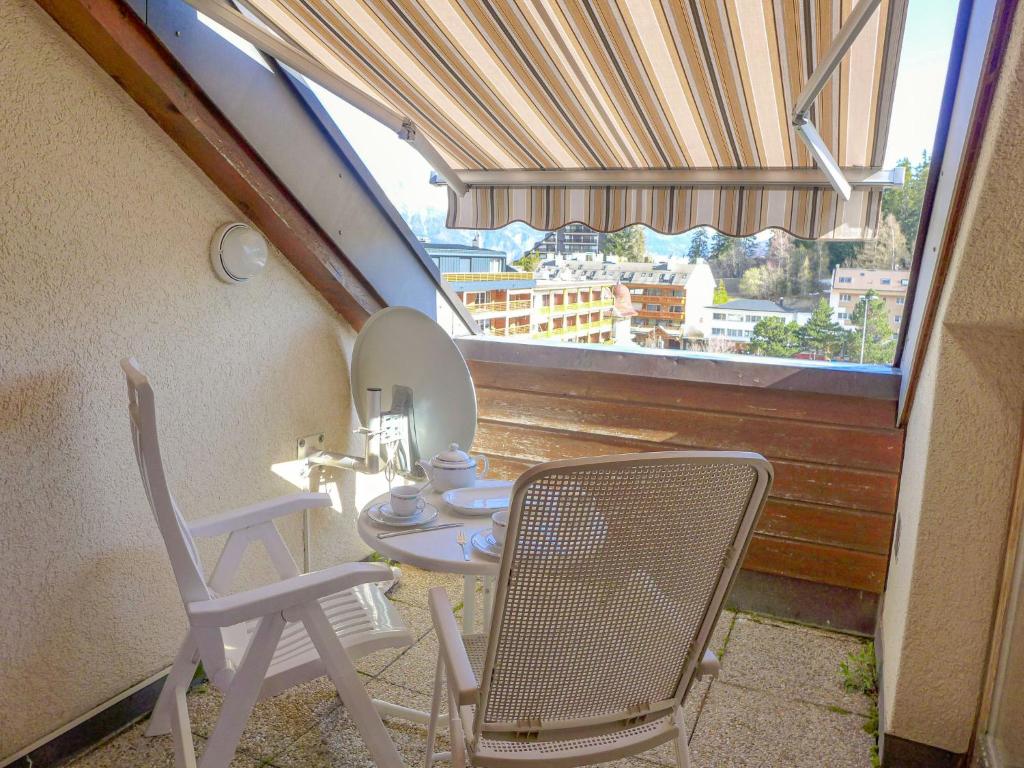 balcón con mesa, sillas y espejo en Apartment les Vignettes by Interhome en Crans-Montana
