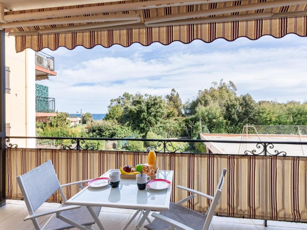 einen Tisch und Stühle auf einem Balkon mit Aussicht in der Unterkunft Apartment La Nuit de Mai-5 by Interhome in Saint-Aygulf