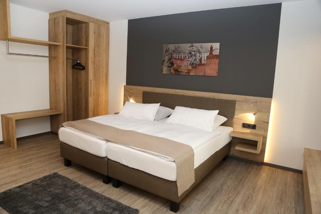 una camera da letto con letto, lenzuola e cuscini bianchi di Hotel Lindleinsmühle a Würzburg
