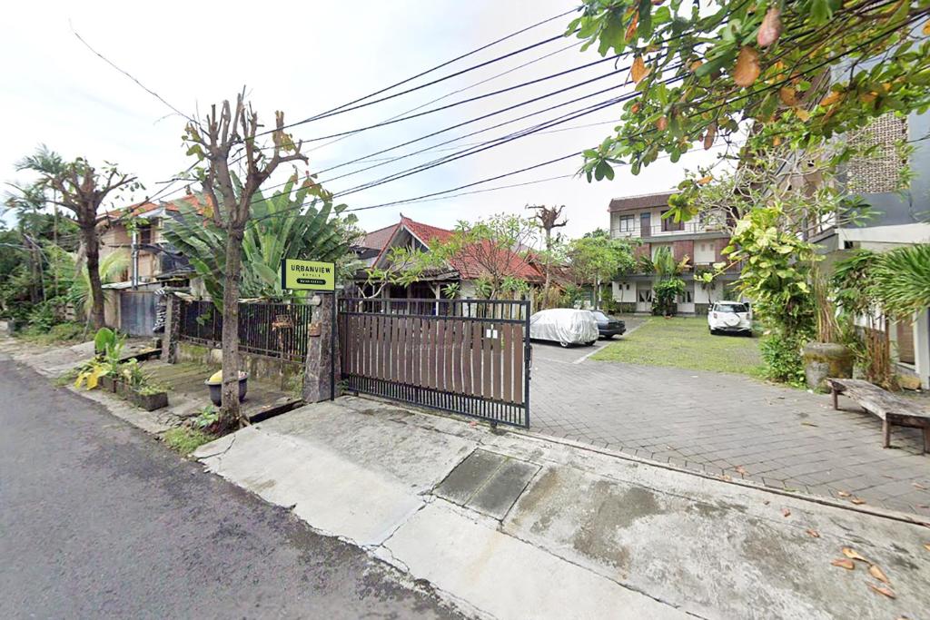 a street with a gate in a residential neighborhood at Urbanview Hotel Wayan Mansion in Denpasar