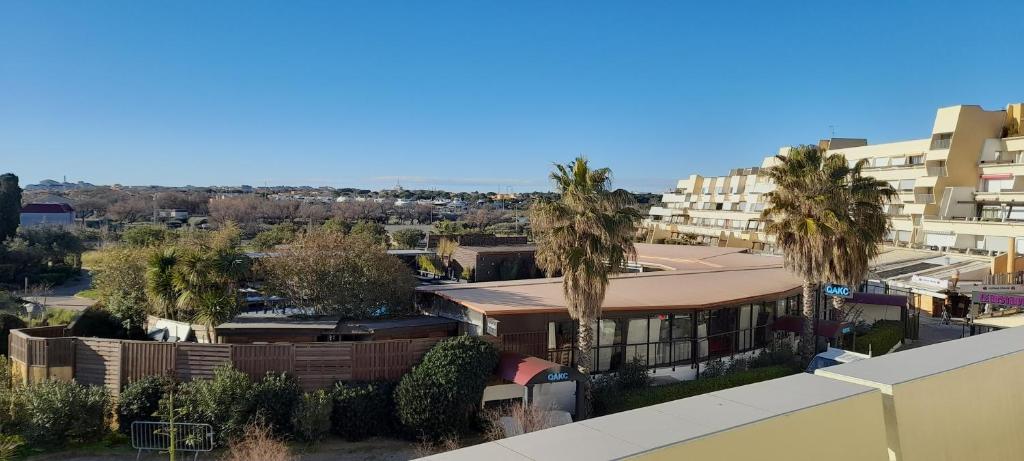 - une vue aérienne sur un bâtiment avec des palmiers dans l'établissement Appartement Village Naturiste Psikedelik, au Cap d'Agde