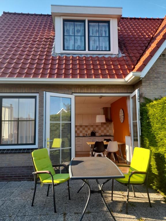 een patio met stoelen en een tafel voor een huis bij Appartement Kooiker in Buren