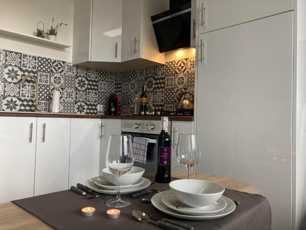 a table with two glasses and a bottle of wine at Apartament Miodowa 9 in Zwierzyniec