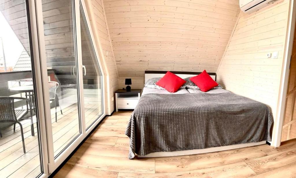Un dormitorio con una cama con almohadas rojas. en Niko Jeziorsko, 