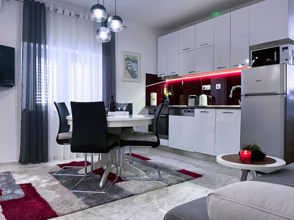 a kitchen with a table and chairs in a room at Apartment Vitturina in Kaštela
