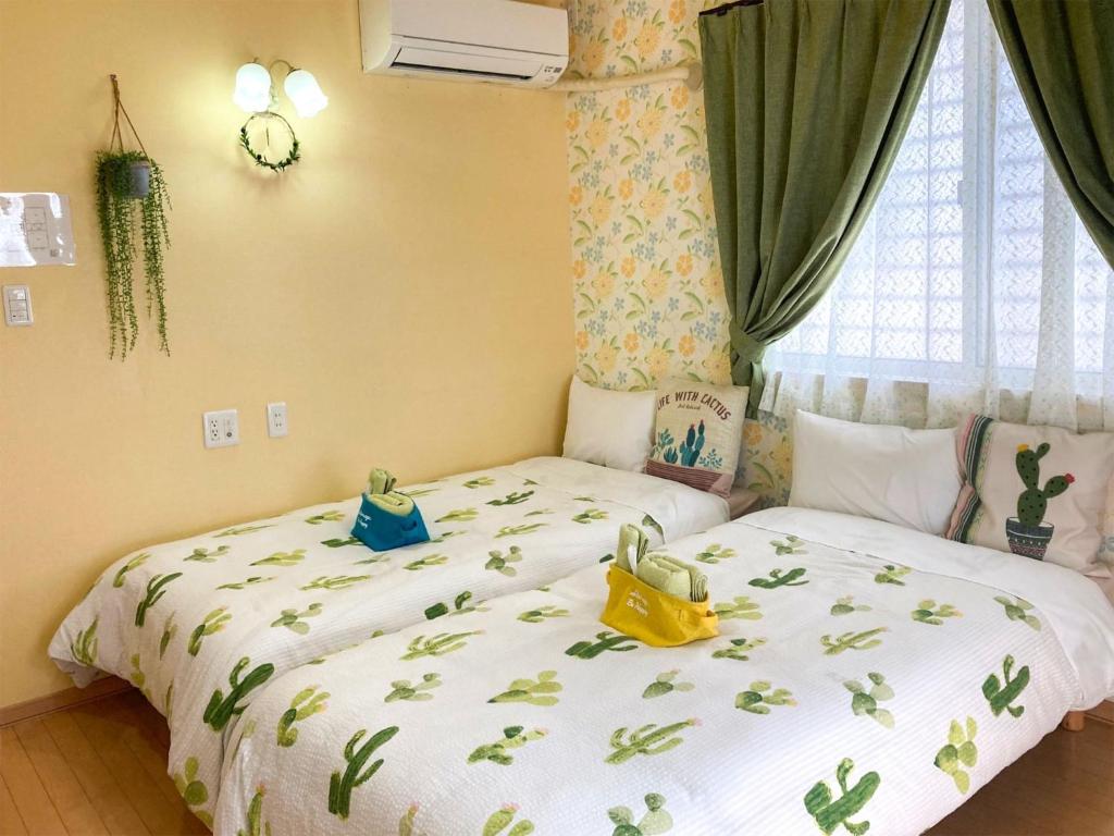 a bedroom with two twin beds and a window at Pension Marinetown Aratta Vacation STAY 13299 in Yonabaru