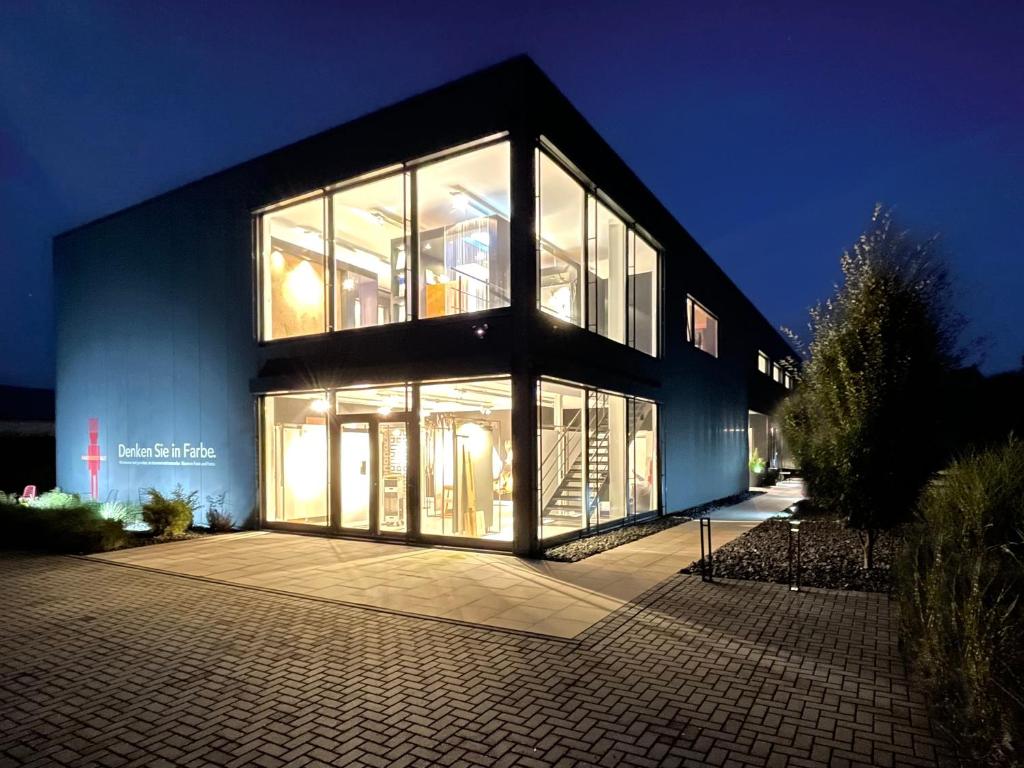- un grand bâtiment avec de grandes fenêtres la nuit dans l'établissement Guestroom by "FARBGESTALT", à Sarstedt