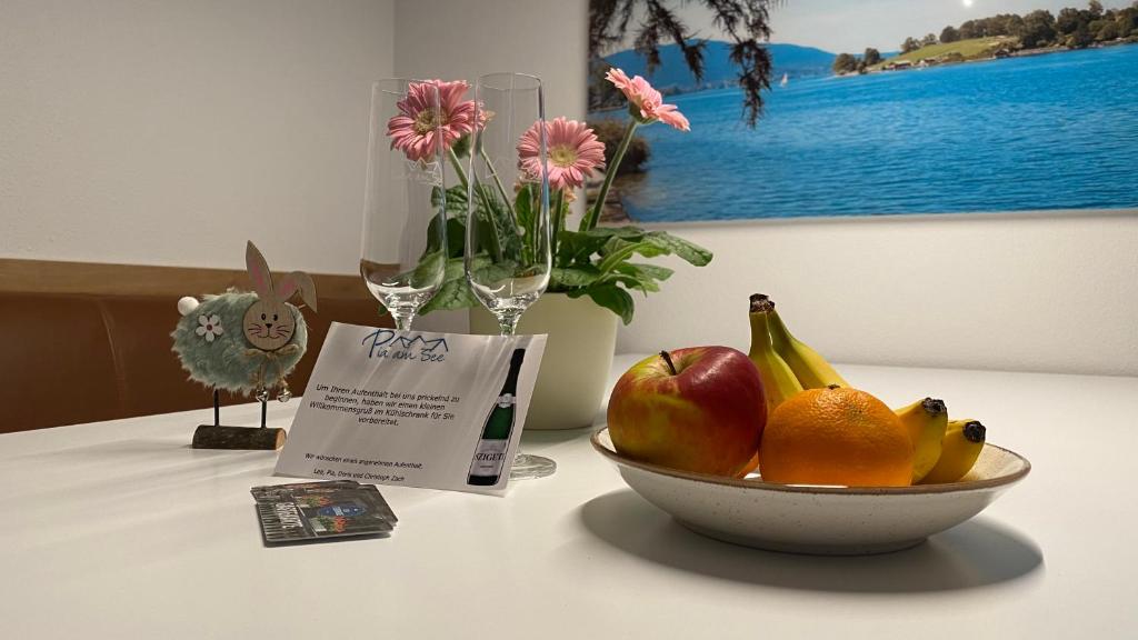a bowl of fruit sitting on a table with a sign at Pia am See - Bio Design Appartement in Bad Wiessee