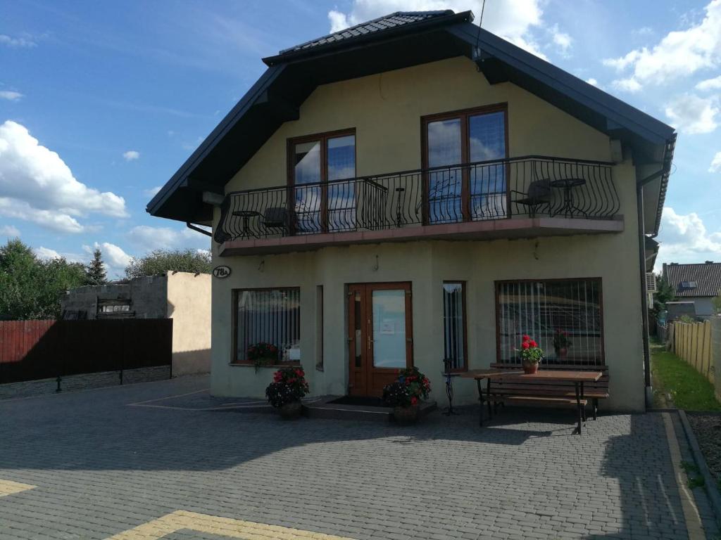 a small house with a balcony and a bench at Pensjonat Pod Tetrapodem in Zagnańsk