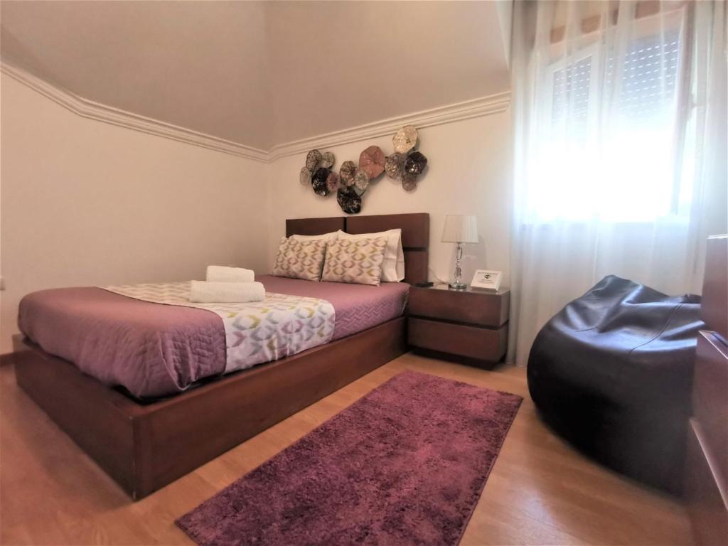 a bedroom with a bed and a purple rug at Anamar in Nazaré