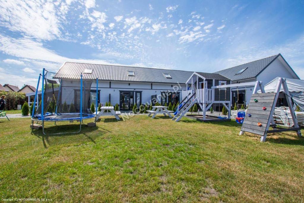 a house with a playground in the yard at Aparts Care Beztroska in Sianozety