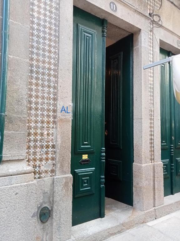 two green doors on the side of a building at Casa da Celeira in Ponte de Lima