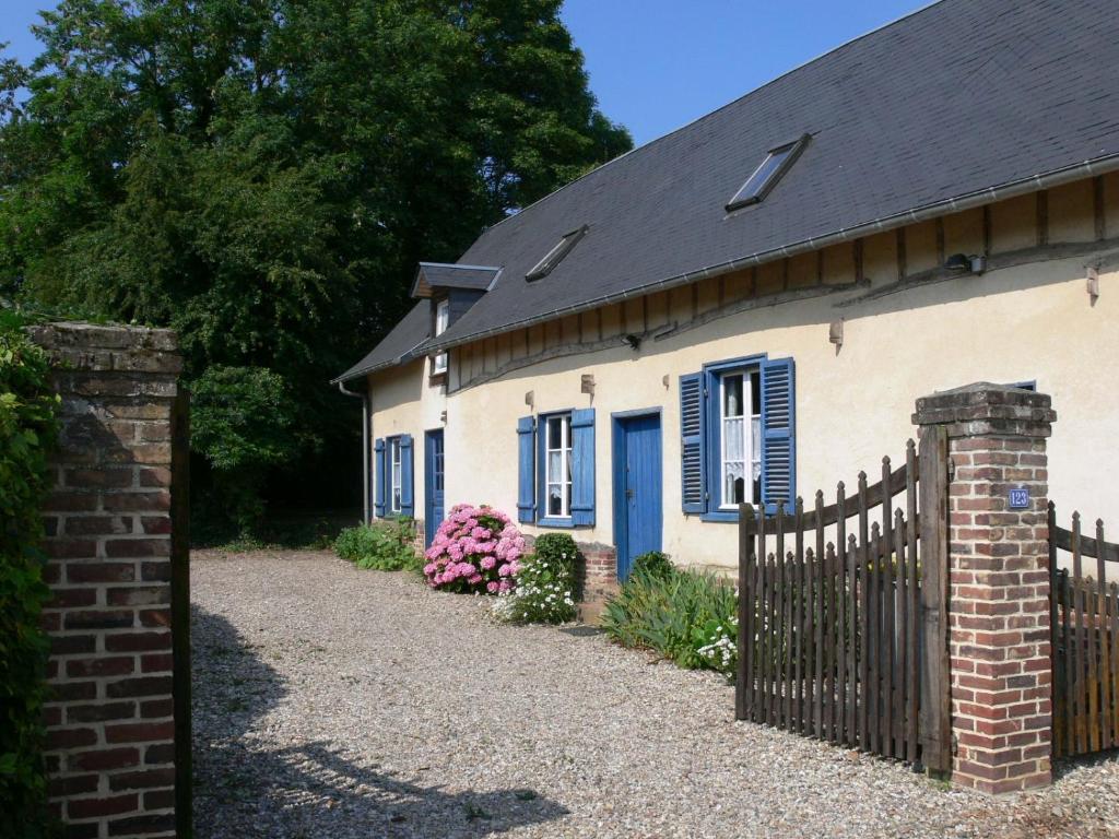 Casa blanca con ventanas azules y valla en GITE Le Bosquet en Chépy