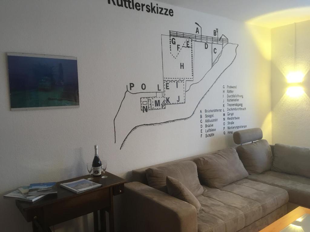 a living room with a couch and a drawing on the wall at Ferienwohnung Tauchen im Kreidesee in Hemmoor