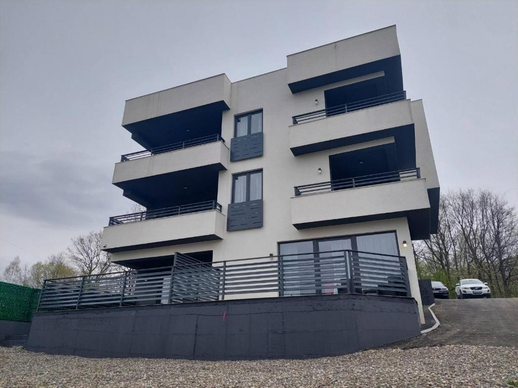 un edificio bianco con balconi e un parcheggio di Deluxe Feliciano Apartments a Visoko
