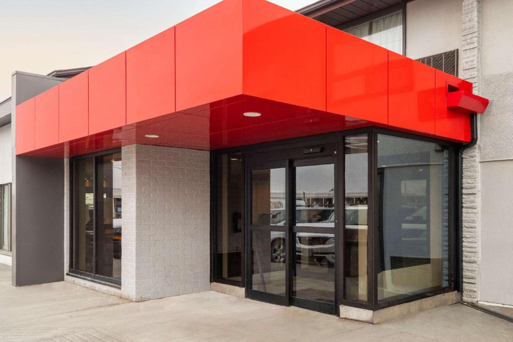 a red canopy over a building with glass doors at Comfort Inn Ottawa East in Ottawa