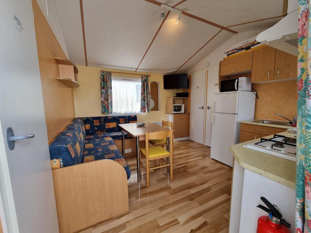 a small kitchen and living room in a caravan at La belle Perrochoise 13 mobilhome in La Cotinière