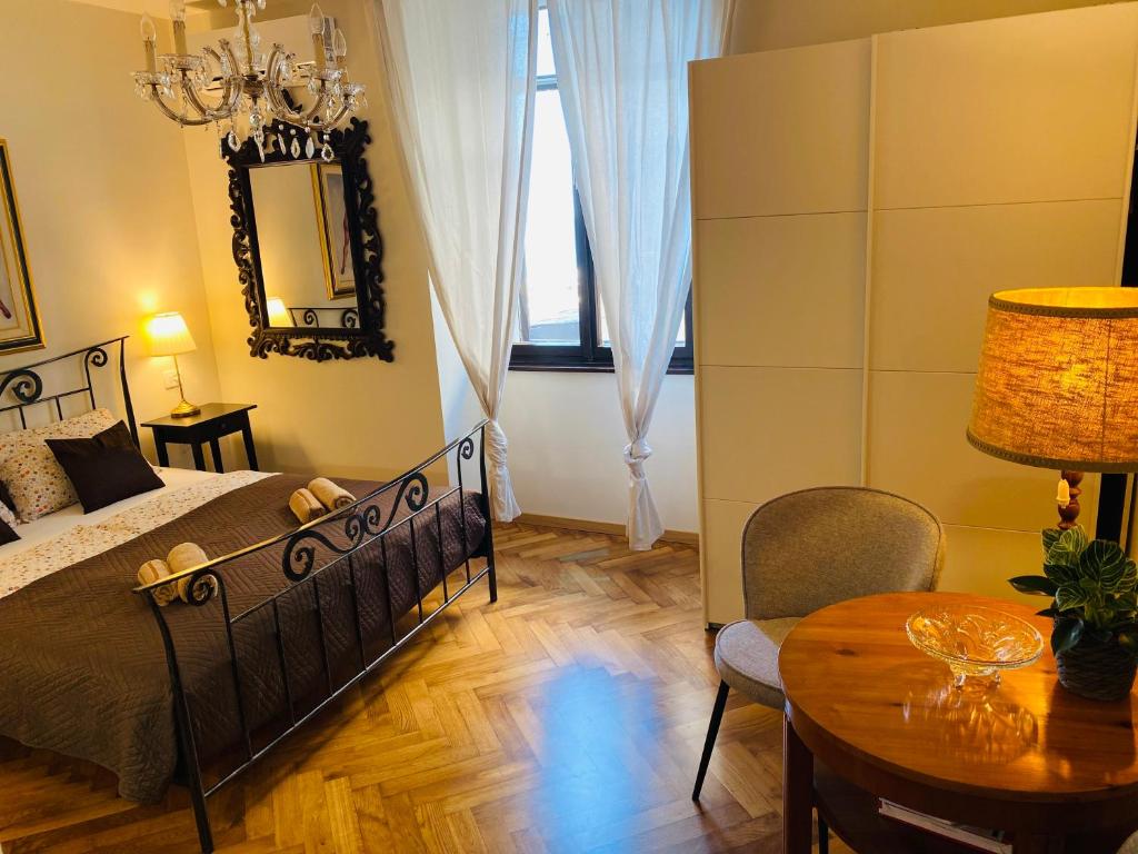 a bedroom with a bed and a table and a mirror at VISUM Apartments in Piran