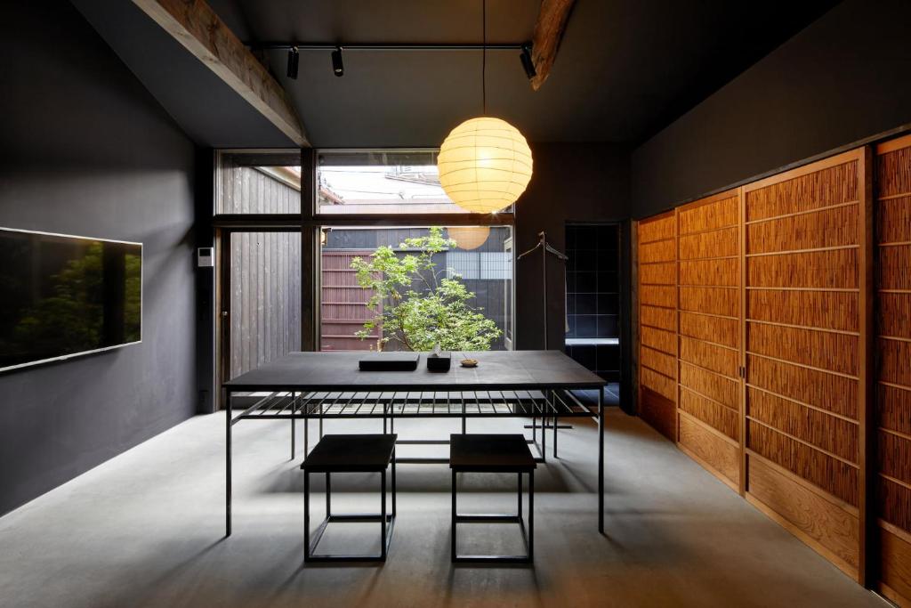 a dining room with a table and chairs and a window at YADORU KYOTO HANARE Washi No Yado in Kyoto