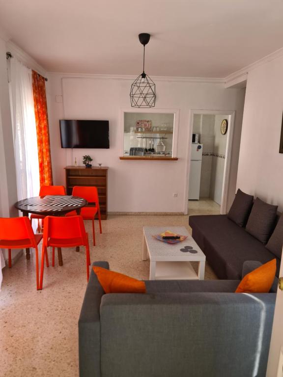 een woonkamer met een bank en een tafel bij apartamento céntrico jerez calle tucan n17 in Jerez de la Frontera
