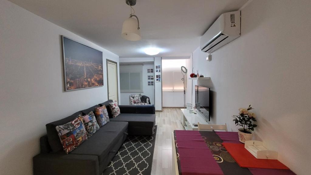 - un salon avec un canapé noir et un tapis dans l'établissement APARTAMENTS B O D CoLLBLANC, à L'Hospitalet de Llobregat