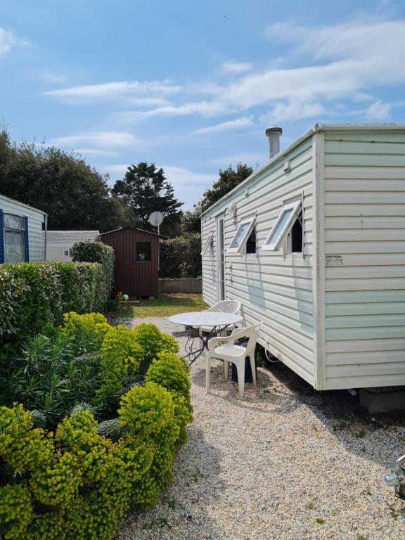 une remorque blanche avec une table de pique-nique et un banc dans l'établissement La belle Perrochoise 2 mobilhome, à La Cotinière