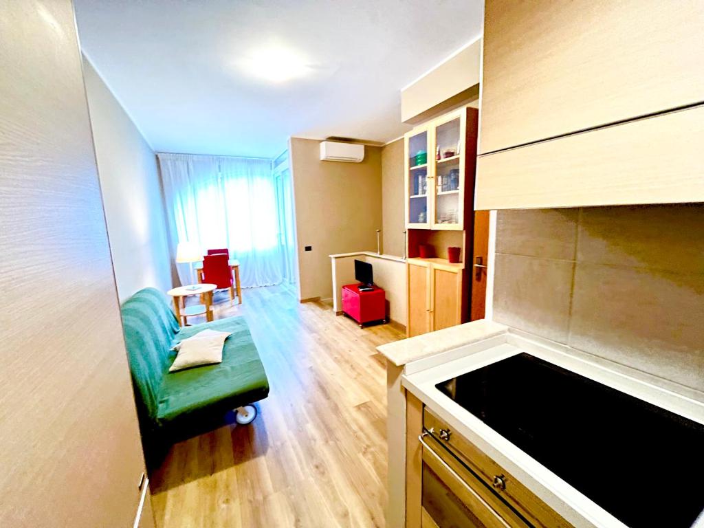 una piccola cucina con divano verde in una camera di Inn Bracciano Suite Casa Vacanze a Bracciano