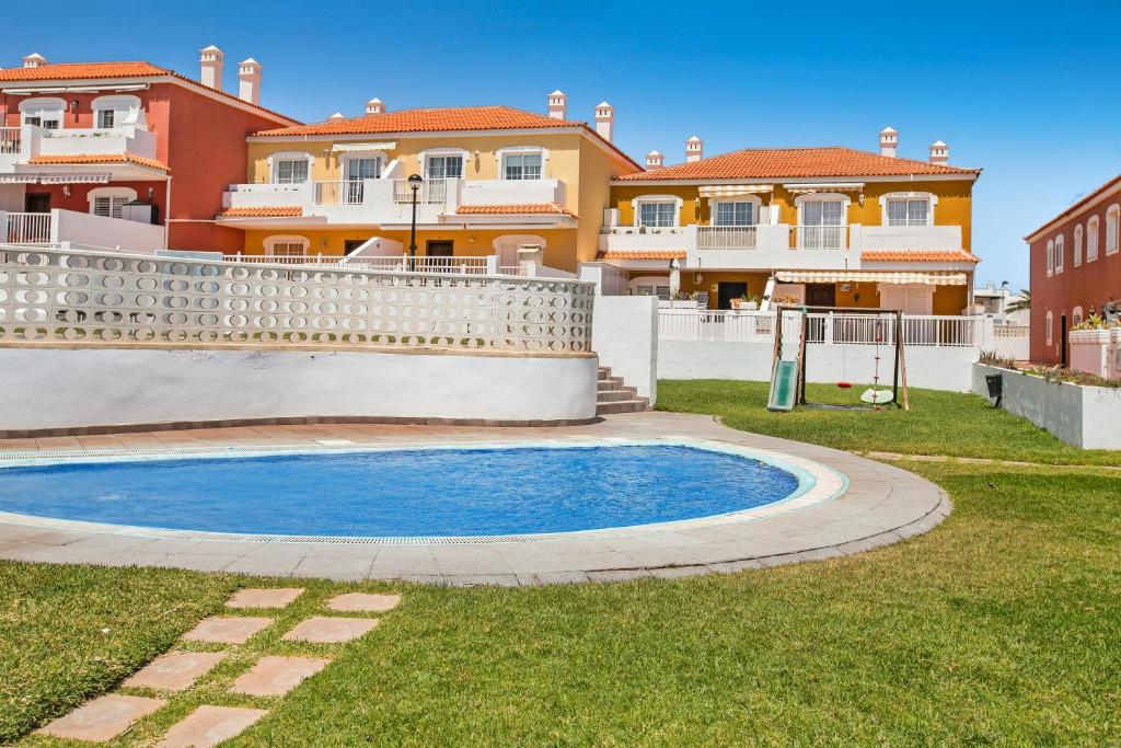 a villa with a swimming pool in front of a house at Apartamento Porís in Poris de Abona