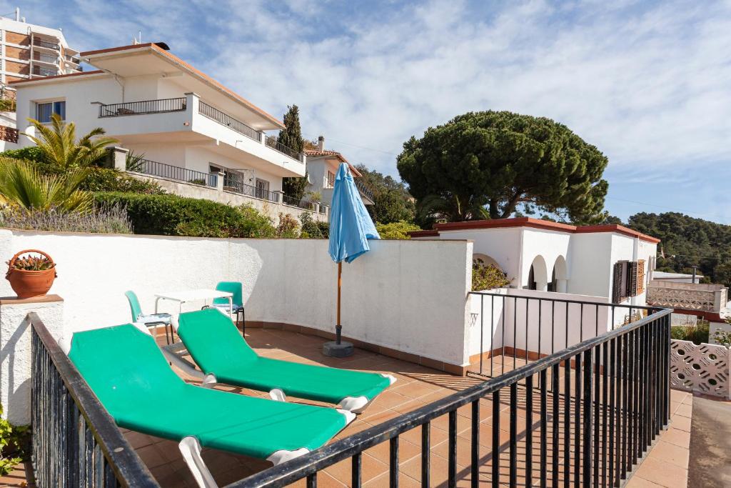 a balcony with two lounge chairs and an umbrella at Casa Morisca vistas al mar in Tossa de Mar