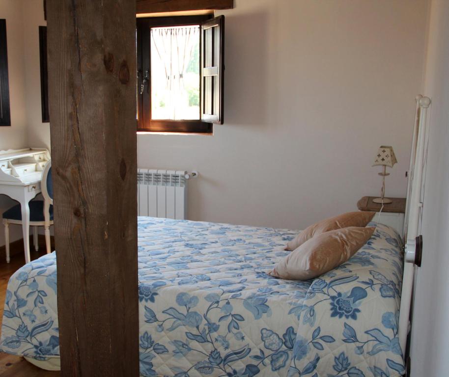 - une chambre avec un lit et une couette bleue et blanche dans l'établissement El Mirador del Hayedo, à Ríofrío de Riaza