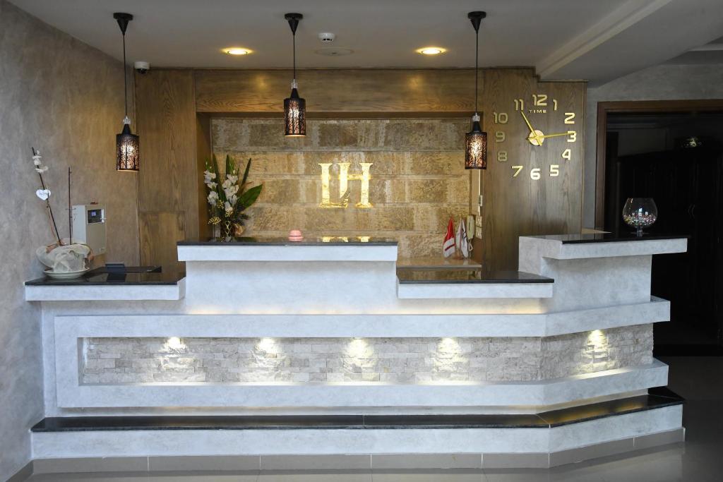 a lobby with a staircase with lights and a clock at Larimar Hôtel Sfax in Sfax