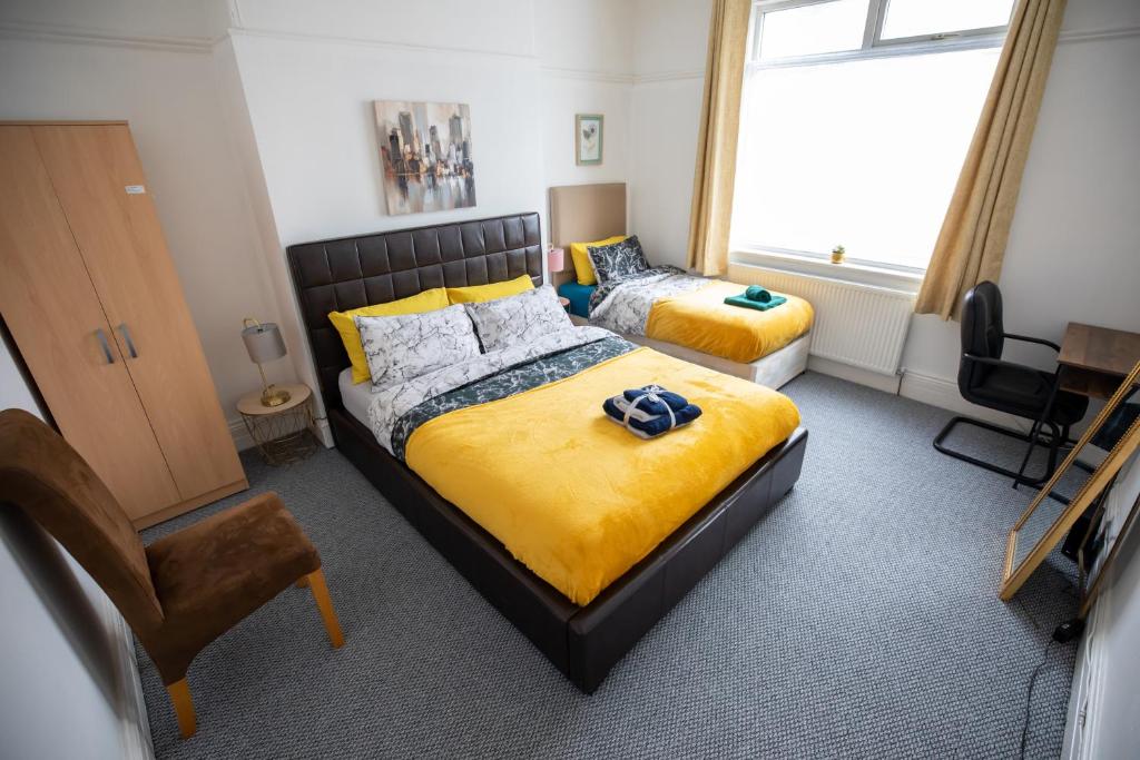 1 dormitorio con 2 camas, silla y ventana en Sterling Aparment en Wallsend-on-Tyne