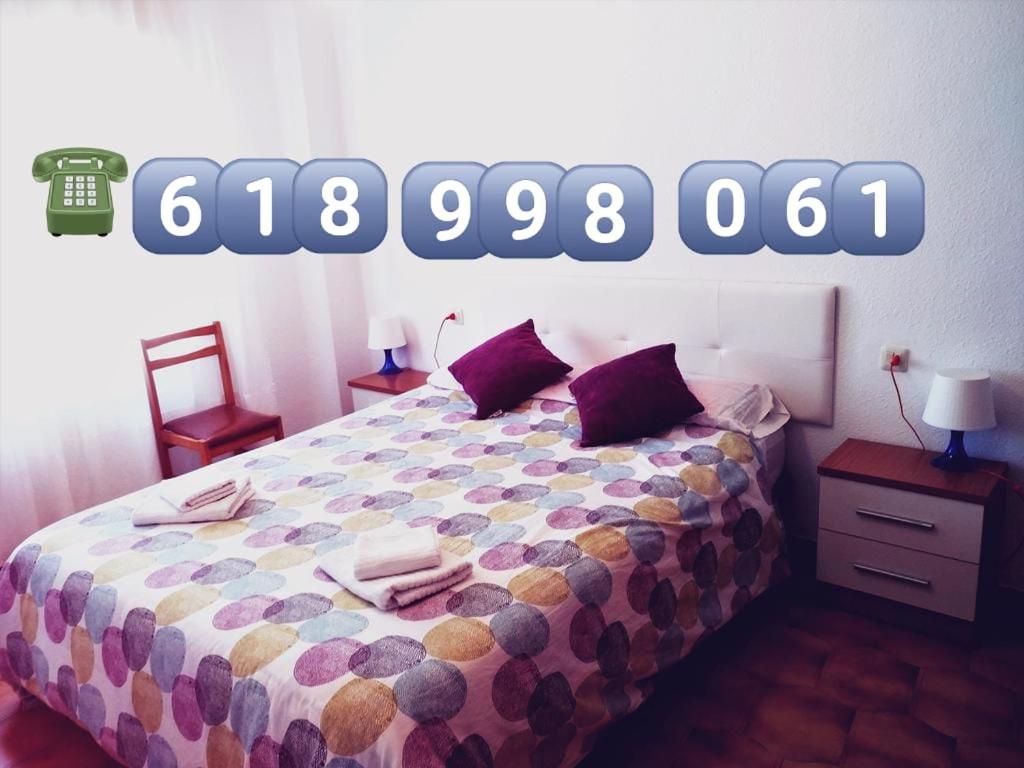 テルエルにあるApartamento 3 habitaciones en el centro de Teruelのベッドルーム1室(壁に看板付)