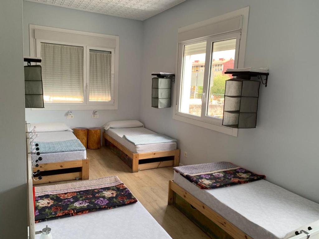 a bedroom with two beds and a desk at Albergue A ROTONDA in Redondela