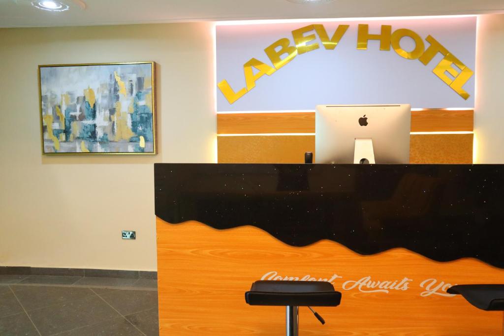 un mostrador de recepción con ordenador portátil encima en Labev Hotel, en Kumasi