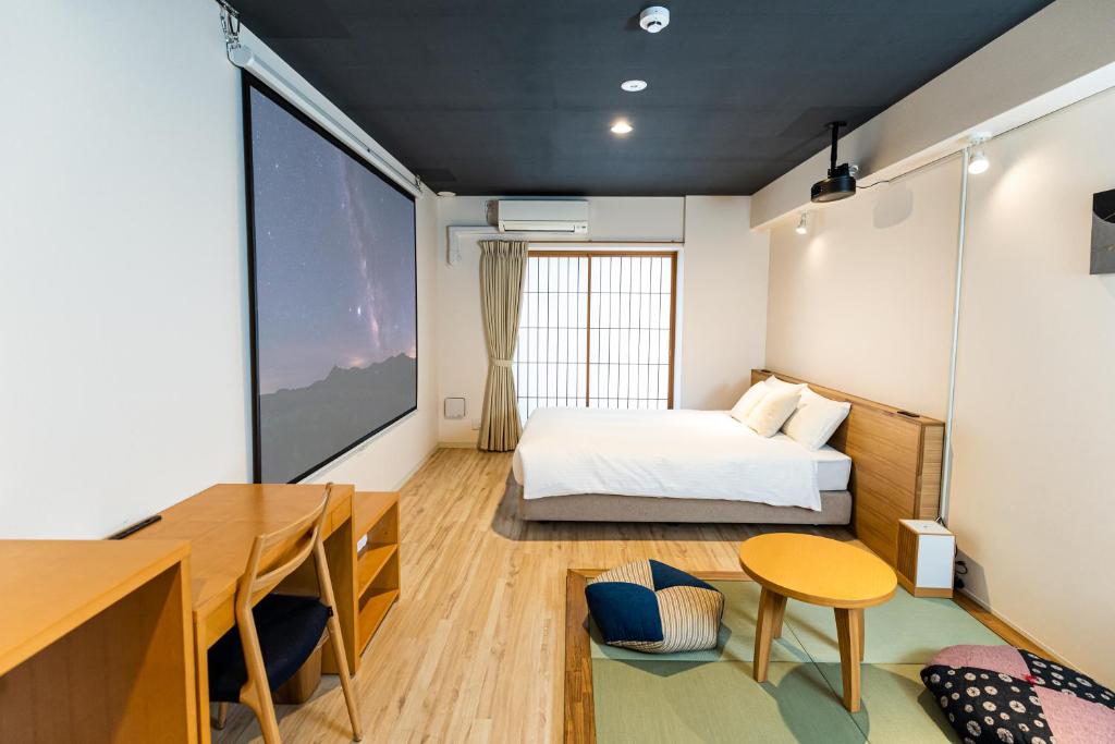 een slaapkamer met een bed, een bureau en een tafel bij Minn Shin-Osaka in Osaka
