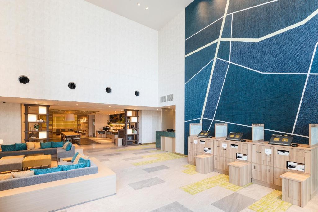 a lobby with blue furniture and a blue wall at SOTETSU GRAND FRESA TAKADANOBABA in Tokyo