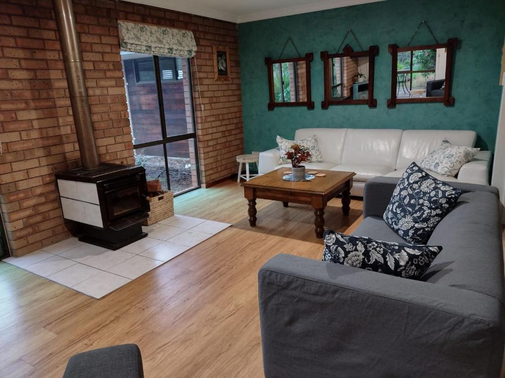 a living room with a couch and a wood stove at Chuditch Holiday Home Dwellingup - Great Central Location in Dwellingup
