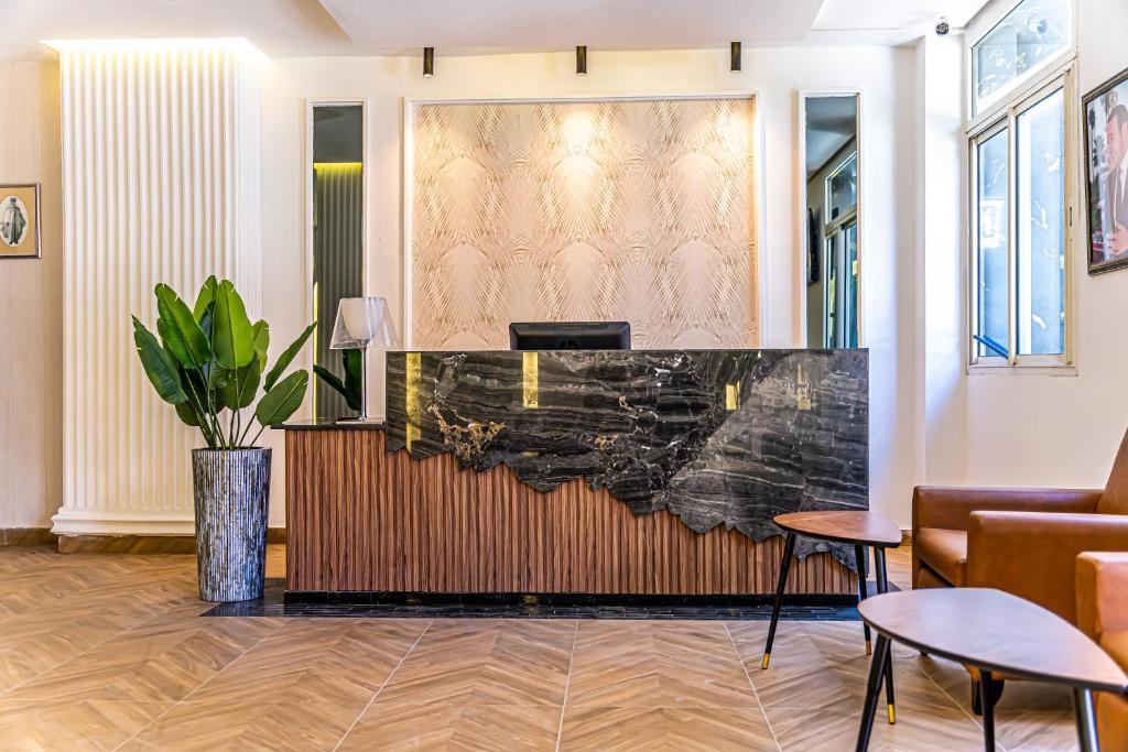 a lobby with a reception desk with a potted plant at Hotel Les Ambassadeurs in Casablanca