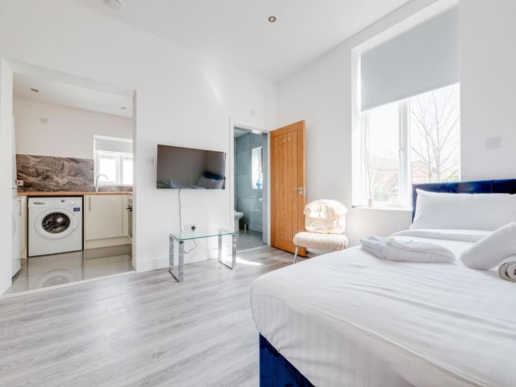 a white bedroom with a bed and a bathroom at Pass the Keys Modern 1 bedroom apartment in Manchester in Manchester