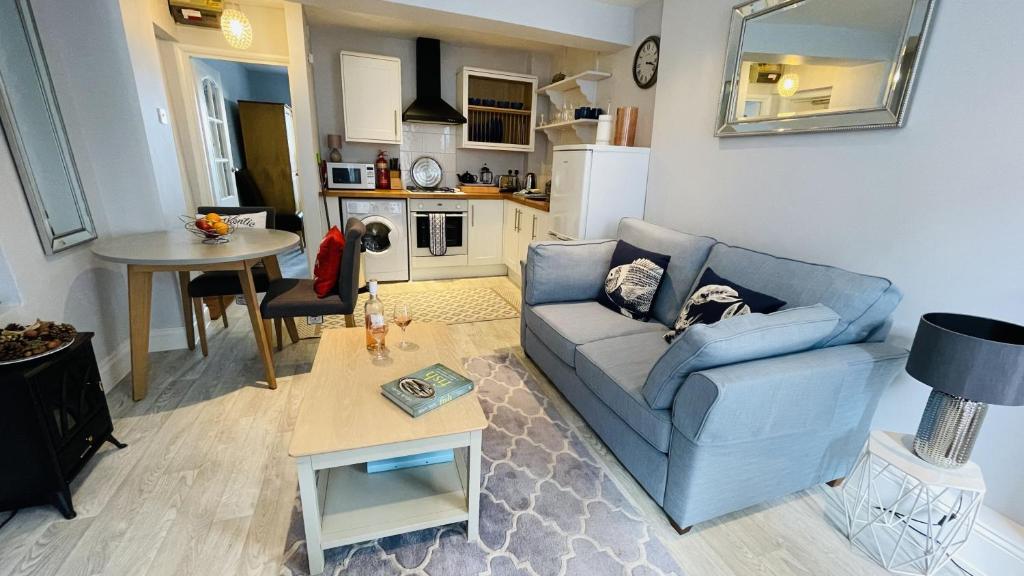 a living room with a blue couch and a table at JC's Cabin - Bijou and charming with parking onsite in Dartmouth