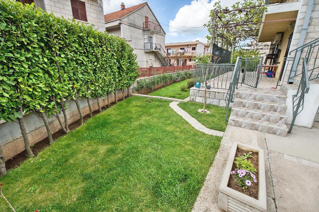une cour avec une pelouse verdoyante et des escaliers dans l'établissement Slobo Apartment, à Trebinje