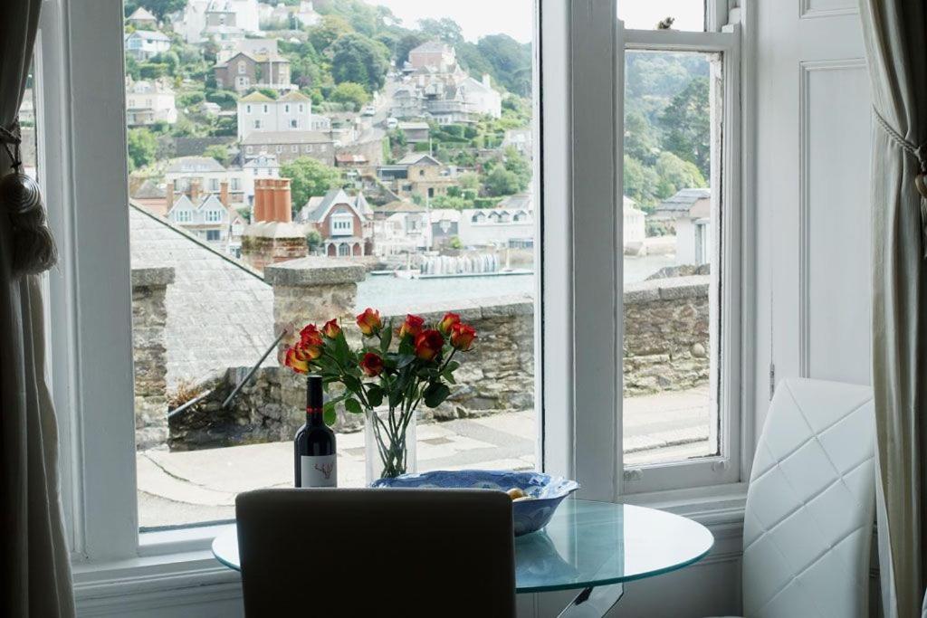 a table with a vase of flowers and a window at 2 Dartview - Close to the Water, River Views, Ground Floor Access in Dartmouth