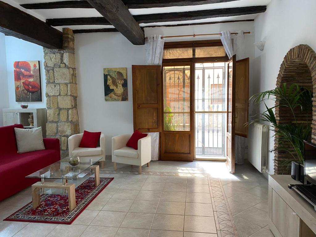 sala de estar con sofá rojo y mesa en La Fanciulla Velca, en Tarquinia