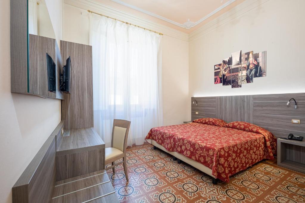 a bedroom with a bed with a red bedspread at Astrid Hotel in Florence